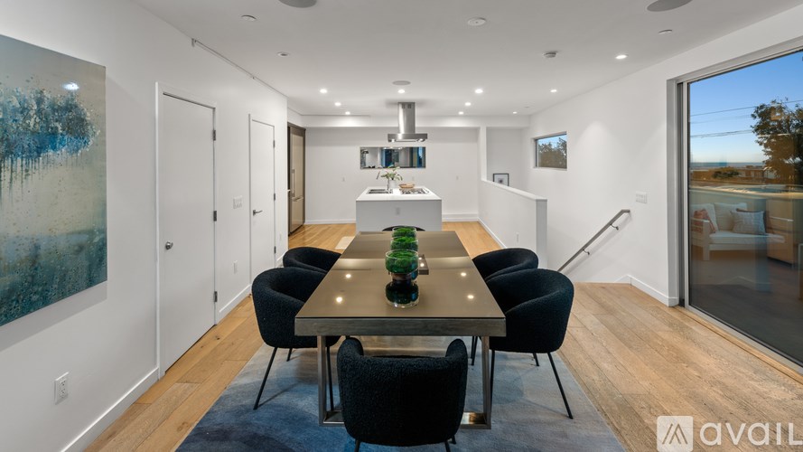 A modern dining room with a large table and chairs.
