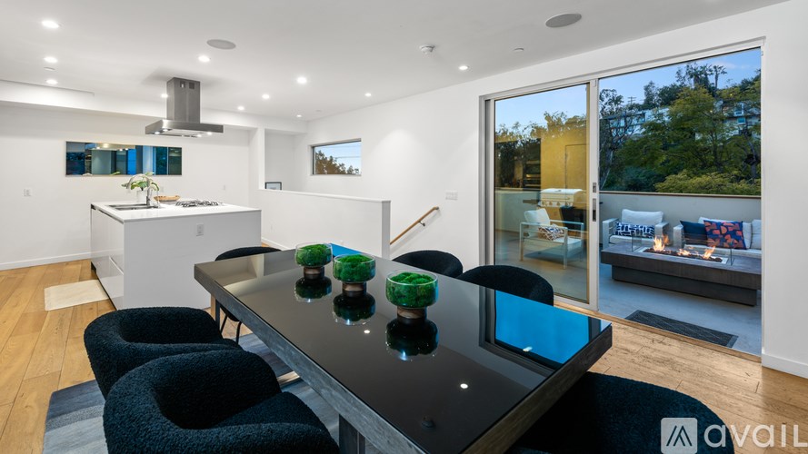 A modern kitchen with a black table and chairs.