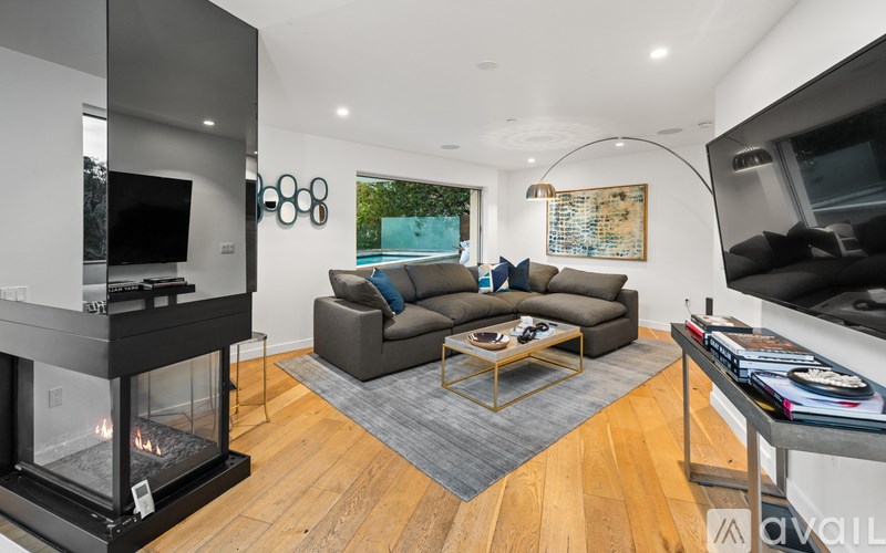 A modern living room with a fireplace and a grey sofa.