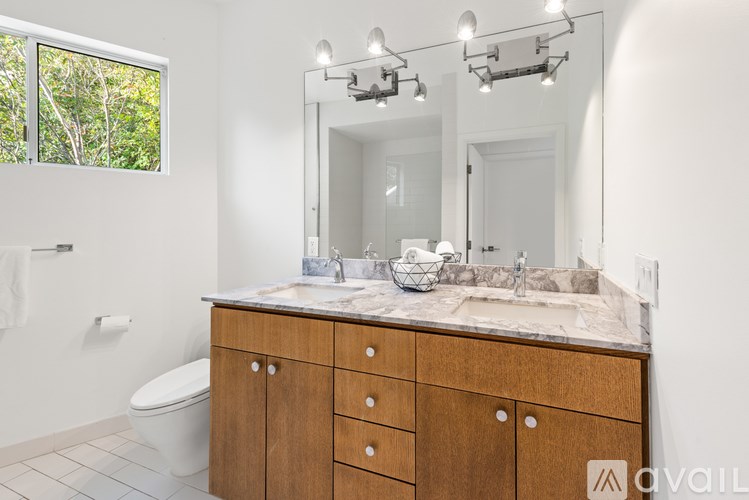 A bathroom with a wooden vanity and a large mirror.
