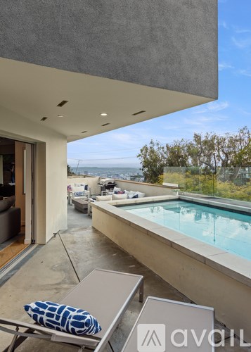 A pool area with a chair and a pillow with the logo "avail" on it.