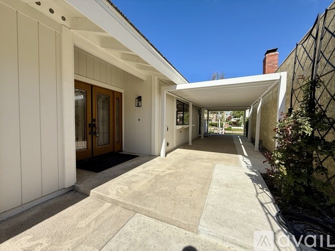 A modern house entrance with a white door and a black mat.