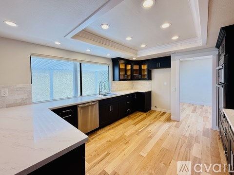 A kitchen with black cabinets and a white countertop.