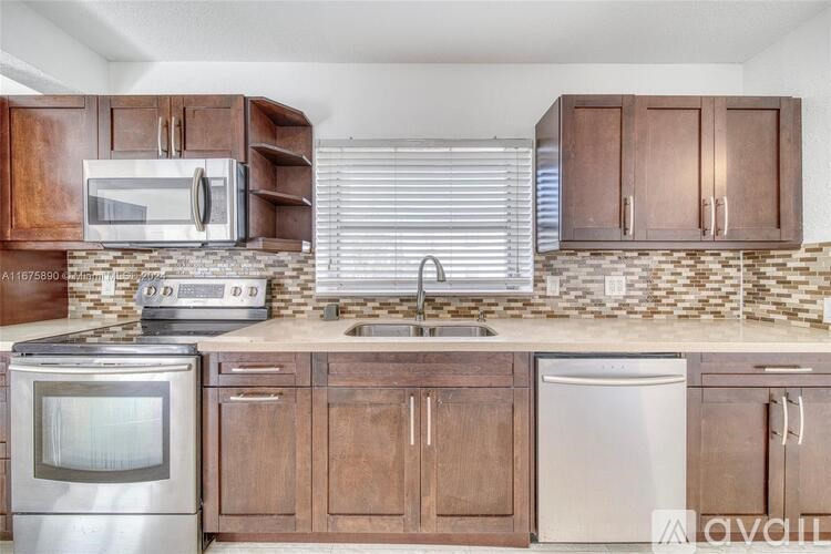 A kitchen with wooden cabinets and stainless steel appliances.