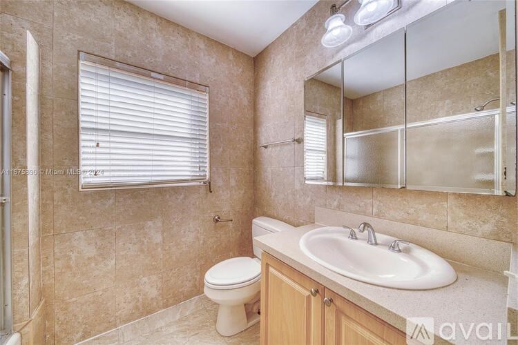 A bathroom with a toilet, sink, and mirror.