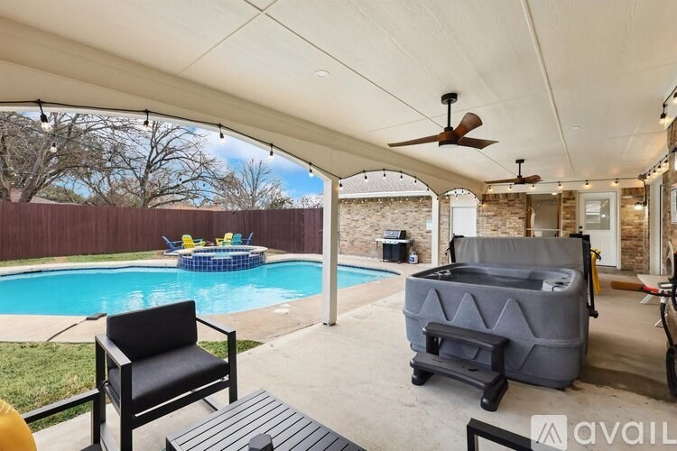 A patio with a black chair and a table is shown.