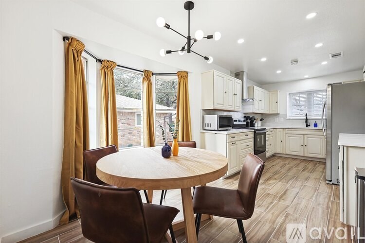 A kitchen with a table and chairs in front of a window.