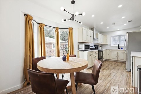 A kitchen with a table and chairs in front of a window.