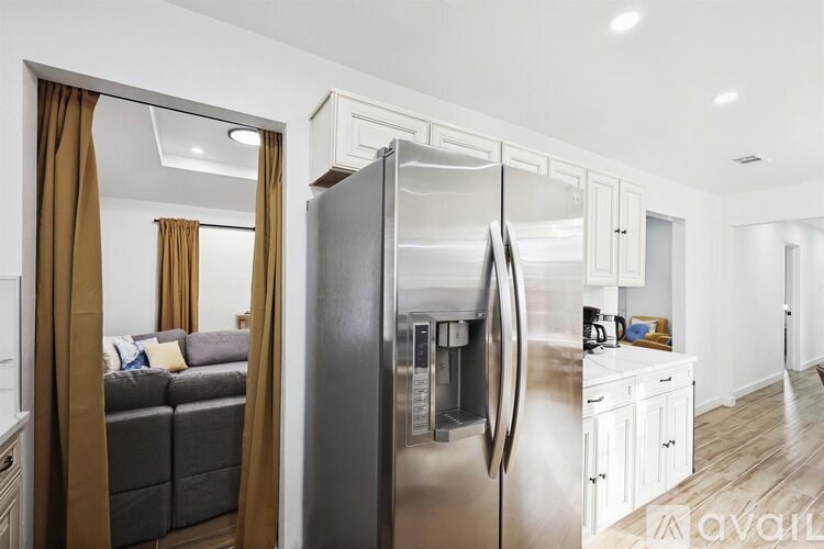 A modern kitchen with a refrigerator and cabinets.