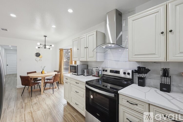 A kitchen with a dining table and chairs.