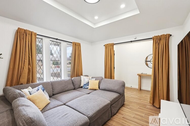 A living room with a grey sofa and yellow pillows.