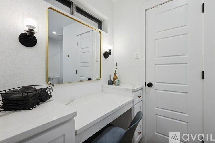 A bathroom with a white counter and a mirror above it.