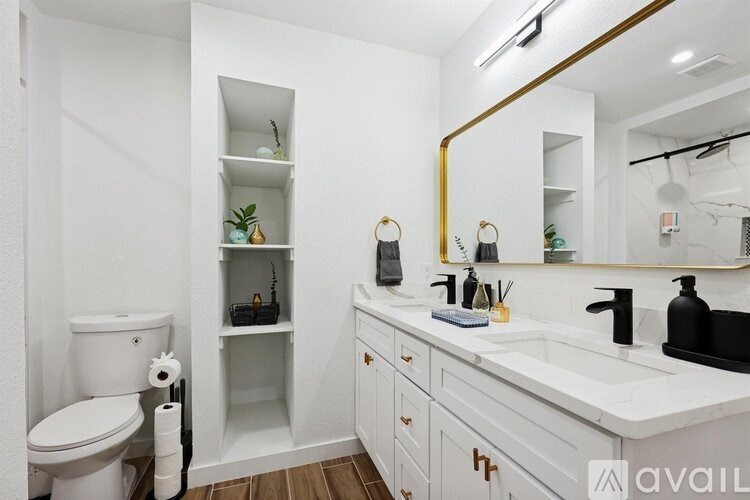 A white bathroom with a toilet, sink, and mirror.