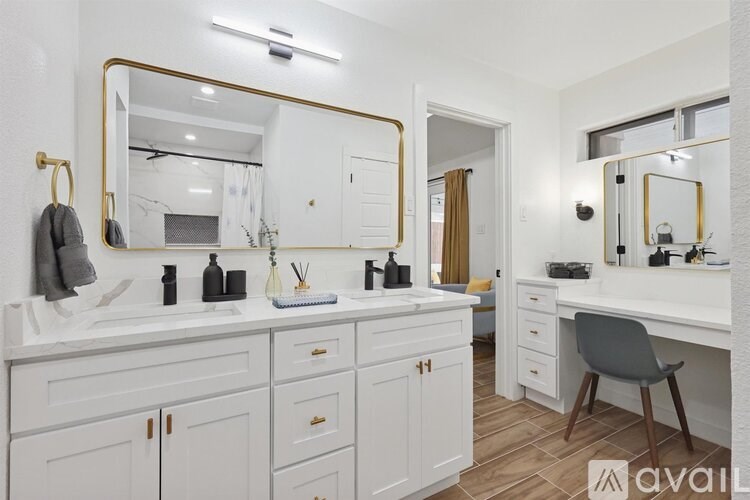 A bathroom with a vanity and a chair.