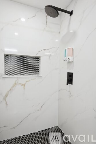 A shower head mounted on a marble wall.