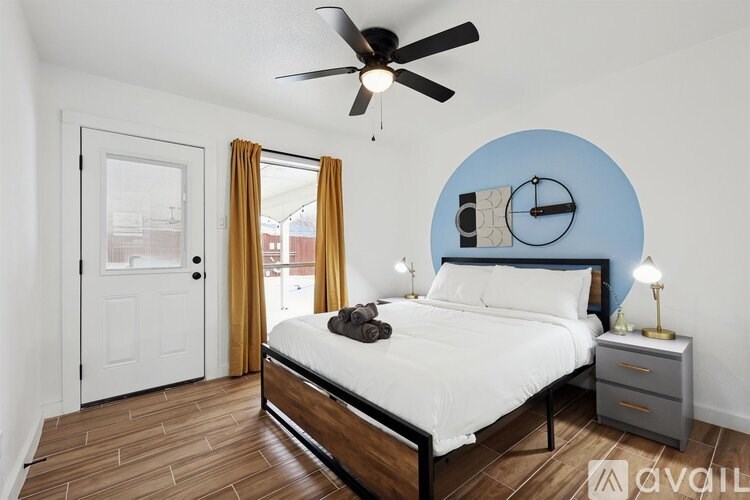 A bedroom with a bed, nightstand, and a ceiling fan.