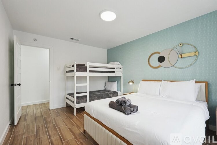 A bedroom with a white bed and a bunk bed.