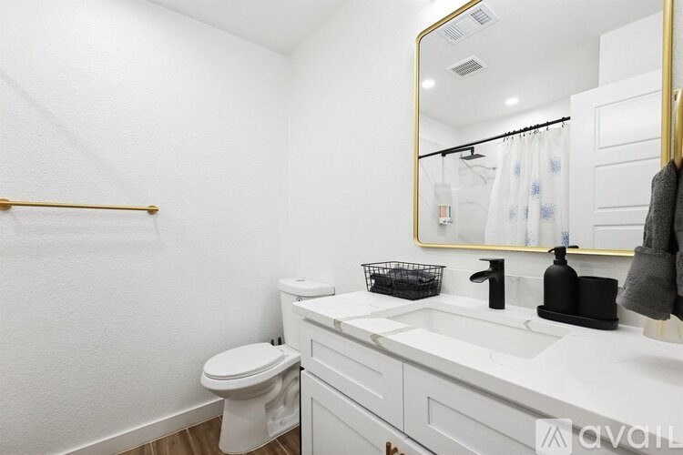 A bathroom with a white toilet, white sink, and a mirror.