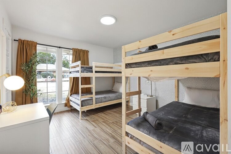 A room with two bunk beds and a desk.