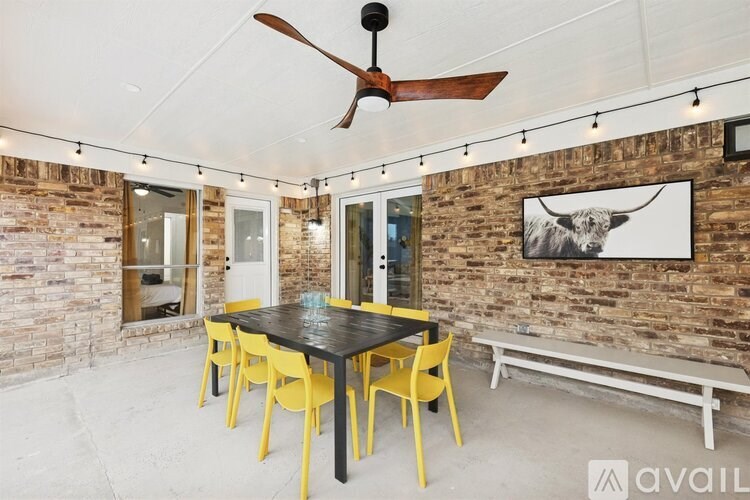A room with a brick wall and a ceiling fan.