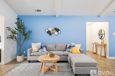 A living room with a grey couch and a wooden coffee table.