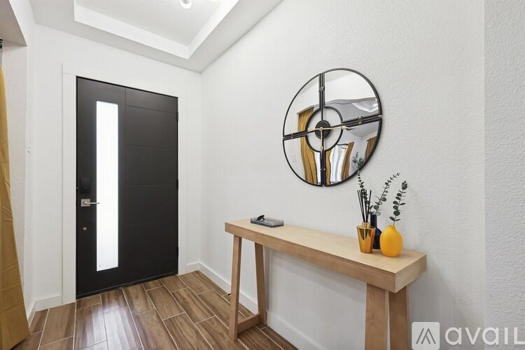 A black door is on the left and a wooden table is on the right.