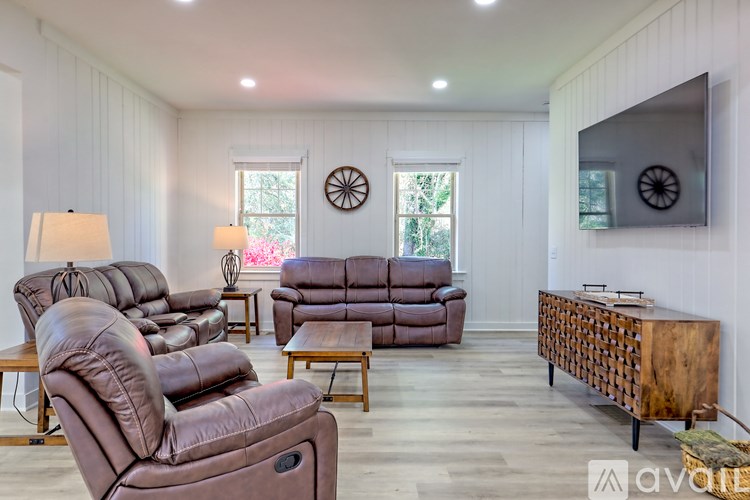 A living room with brown leather furniture and a wooden cabinet.