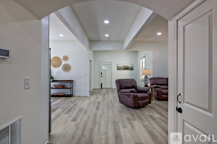 A living room with a white wall and a wooden floor.