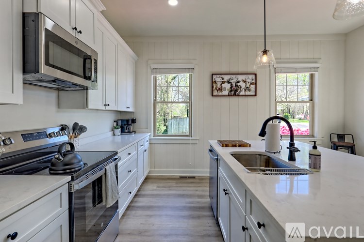 A kitchen with white cabinets and a stainless steel sink.