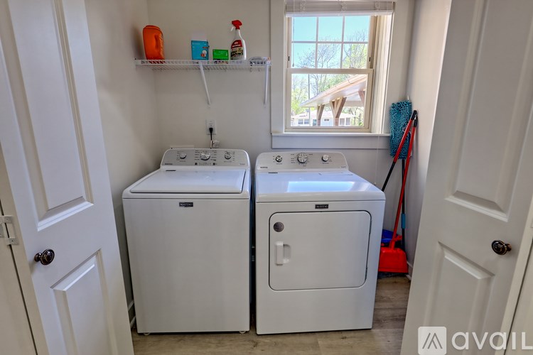 A small laundry room with two washers and a window.