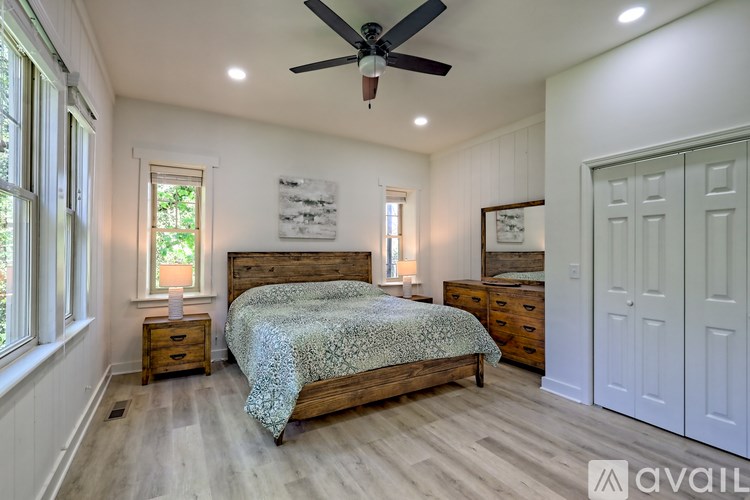A bedroom with a bed, dresser, and ceiling fan.