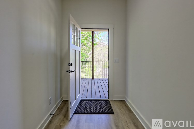 A hallway with a door leading to a balcony.