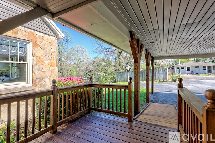 A wooden deck with a stone pillar and a window.