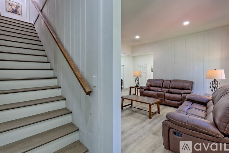 A living room with a couch and a staircase.