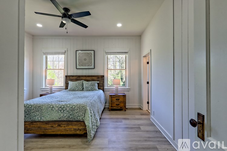 A bedroom with a bed, dresser, and window.