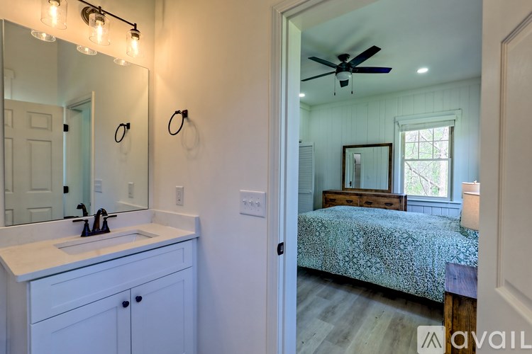 A bathroom with a sink, mirror, and lighting fixture.