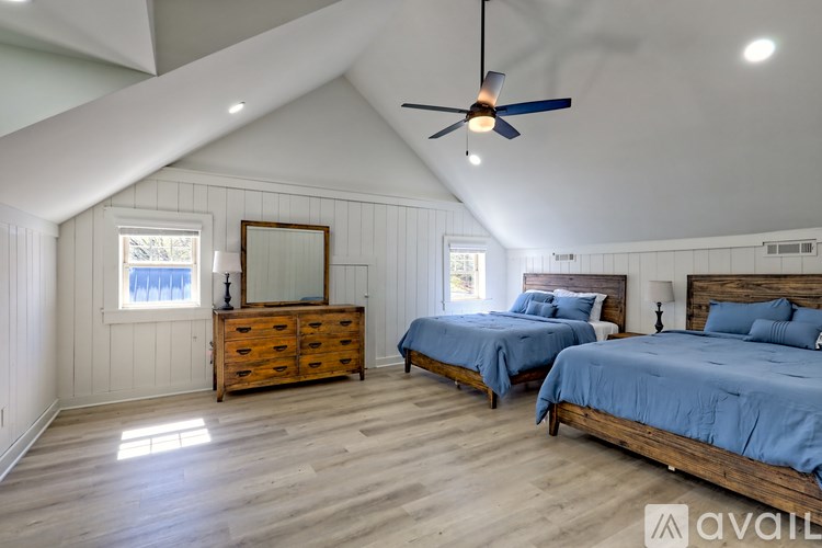 A bedroom with two beds and a dresser.