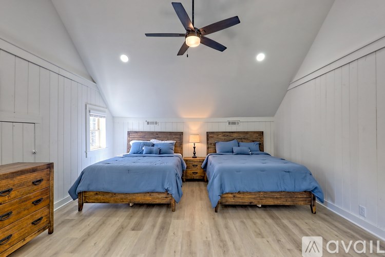 A bedroom with two beds and a ceiling fan.