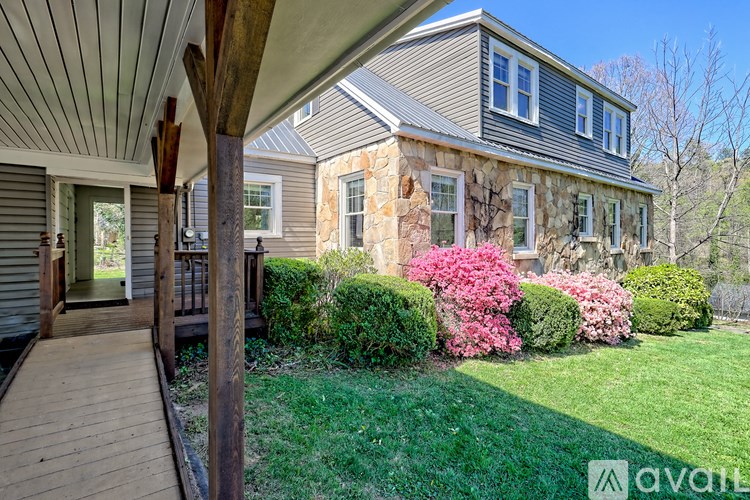 A house with a wooden deck and a stone wall.