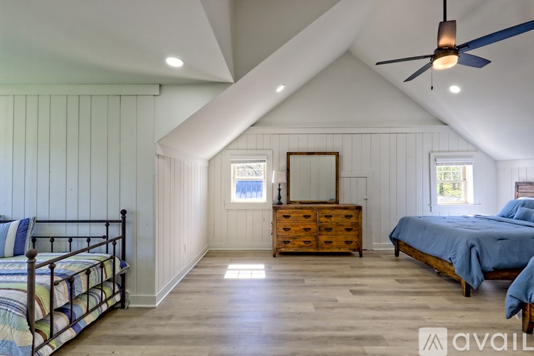 A bedroom with a bed, dresser, and window.