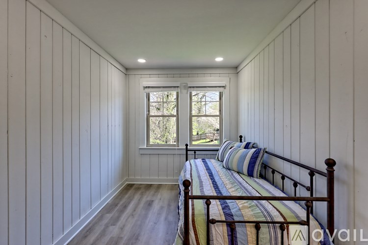A bedroom with a bed and a window.