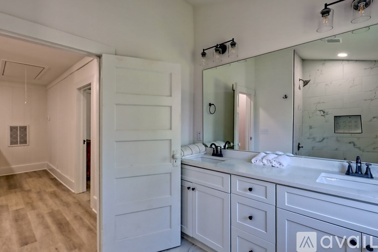 A bathroom with a white vanity and a mirror above it.