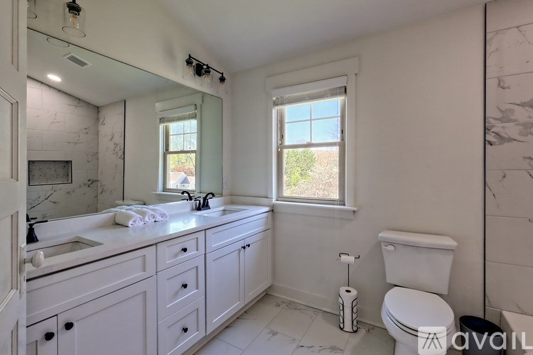 A bathroom with a white toilet, sink, and mirror.