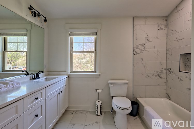 A bathroom with a toilet, sink, and bathtub.