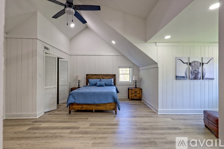 A bedroom with a bed, nightstand, and a ceiling fan.