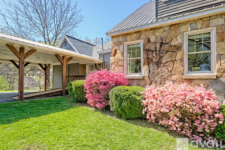 A house with a stone wall and a covered patio.