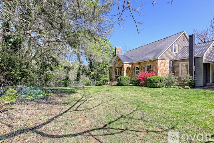 A house with a grey roof and a green lawn in front.