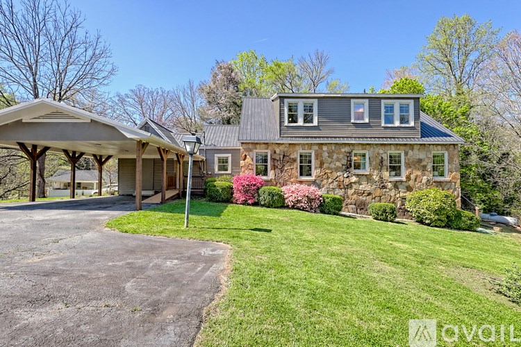 A house with a covered patio and a stone wall.
