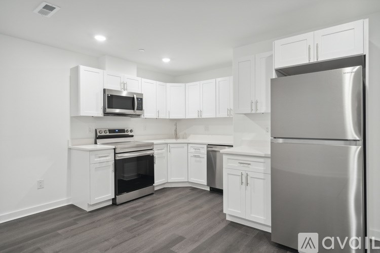 A kitchen with white cabinets and a stainless steel refrigerator.