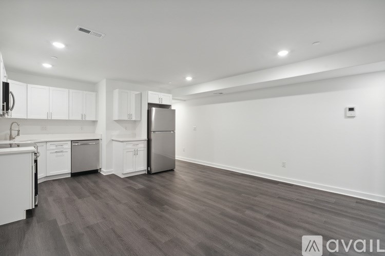 A kitchen with white cabinets and a refrigerator.